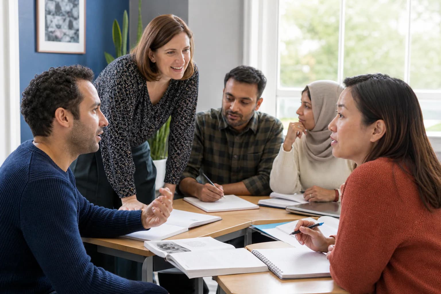 Adult English learners practise conversation in class